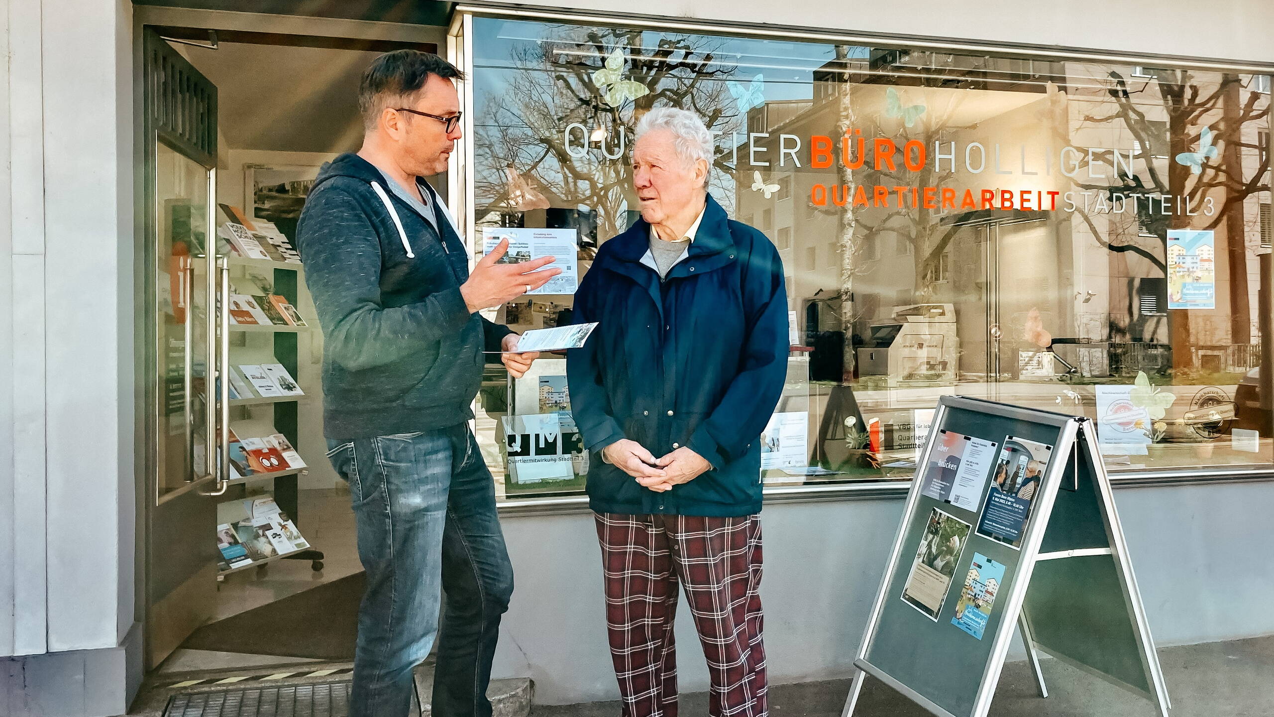 Eingang und Schaufenster des Quartierbüro Holligen, mit Quartierarbeiter Jörg Rothhaupt (links)