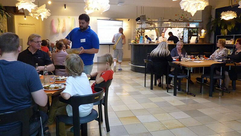 Menschen an den Tischen im Café Tscharni