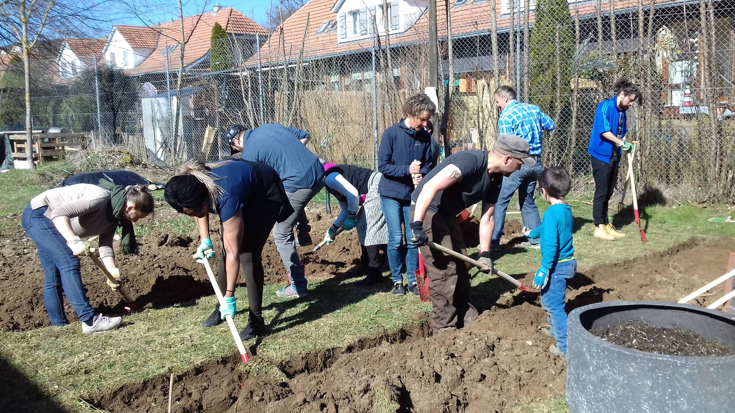 Mehrere Menschen machen Gartenarbeit im Frühling